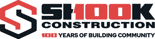 Shook Construction logo with a red and black S symbol. Text reads: Shook Construction. 100 Years of Building Community..