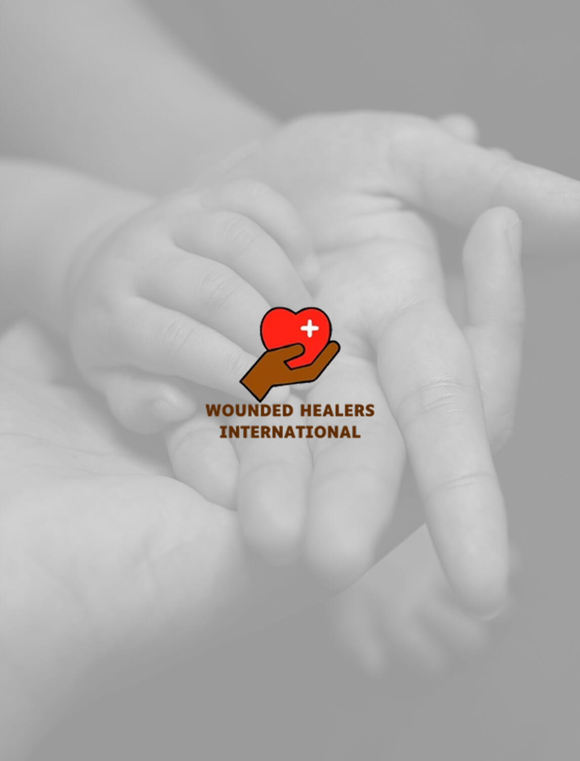 Adult and child hands touching gently with a logo showing a hand holding a heart and a medical cross. Text below reads Wounded Healers International. Background is grayscale; logo and text are in color.